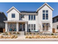 Stunning two-story home with solar panels, inviting porch, and beautifully landscaped front yard at 5835 Chester Way, Denver, CO 80238