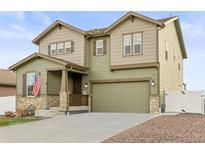Charming two-story home with an attached garage, stone accents, manicured lawn, and an inviting front porch at 1527 Biffle Ct, Berthoud, CO 80513