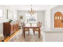 Inviting dining room with vintage wooden furniture, lighting fixture, and hardwood floors at 945 Jackson St, Denver, CO 80206