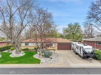 Charming single-story home with a well-maintained lawn, mature trees, and a two car garage at 460 S Taft St, Lakewood, CO 80228