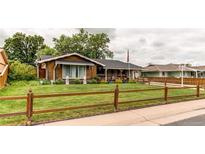 Charming home with a well-manicured lawn and inviting wood fence at 840 Essex Dr, Denver, CO 80229