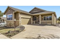 Charming home with a two-car garage, stone accents, and a covered front porch at 23738 E Clifton Pl, Aurora, CO 80016