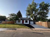 Charming single-story home features a new driveway, new fence, lovely front yard, and a vibrant red front door at 8801 E 16 Ave, Denver, CO 80220