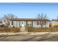 Charming exterior view of a light blue home with a picket fence and arched entrance at 441 Johnson St, Frederick, CO 80530