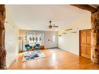 Inviting living room featuring hardwood floors, a ceiling fan, and a sunlit window with decorative curtains at 441 Johnson St, Frederick, CO 80530