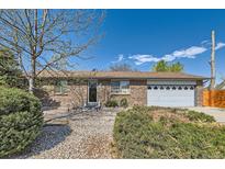 Charming brick home featuring a well-maintained yard with mature landscaping and a two-car garage at 125 S Fulton Ave, Fort Lupton, CO 80621