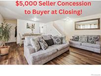 Open living room with a cozy seating area featuring plush couches and a view into the dining room at 8075 Wolff St # H, Westminster, CO 80031
