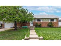 Charming single-story home featuring a brick facade, covered porch, and well-maintained lawn at 11261 Clarkson St, Northglenn, CO 80233