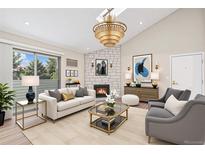 Inviting living room features a fireplace, chandelier, comfortable seating, and natural light at 10150 E Virginia Ave # 13-204, Denver, CO 80247