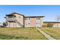 Inviting townhome featuring a well-maintained lawn, neutral color scheme, and a stairway entry to the second level at 1028 Coronado Pkwy # C, Denver, CO 80229