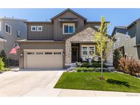 Beautiful two-story home with stone accents, well-manicured lawn, and a charming front porch at 6643 Barnstead Dr, Castle Pines, CO 80108