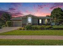 Charming single-Gathering home featuring a well-manicured lawn and stone accents at sunset at 16929 W 63Rd Ln, Golden, CO 80403
