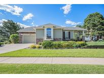 Charming home featuring manicured lawn, stone accents, and a two car garage at 16929 W 63Rd Ln, Golden, CO 80403