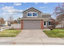 Two-story house with gray siding, brick accents, and a two-car garage at 6370 Wolff St, Arvada, CO 80003