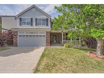 Charming two-story home with a well-manicured lawn, attached two-car garage, and inviting front porch at 20431 E Union Cir, Aurora, CO 80015