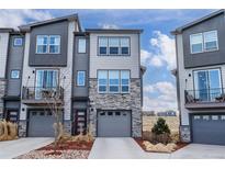 Modern townhome with stone accents, gray siding, attached garages, and small private balcony in a contemporary design at 4355 Cyan Cir # E, Castle Rock, CO 80109