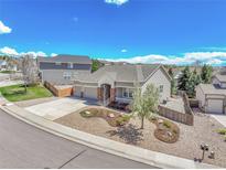 Well-maintained home featuring a three-car garage, manicured landscaping, and a charming front yard at 1034 Halfmoon Dr, Castle Rock, CO 80104