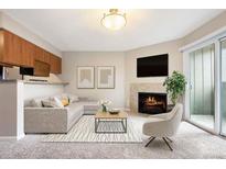 Bright living room featuring a cozy fireplace, plush carpet, and a sliding glass door to a balcony at 695 Manhattan Dr # 5, Boulder, CO 80303