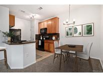 Eat-in kitchen with granite counters and wood cabinets at 2675 S Danube Way # 104, Aurora, CO 80013