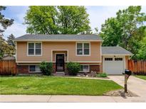 Charming two-story home with a well-manicured lawn, brick accents, and an attached garage at 8410 Gray St, Arvada, CO 80003
