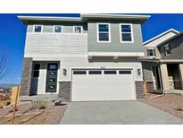 Two story home featuring mixed siding, a two car garage, and modern architectural details at 9237 Truckee Ct, Commerce City, CO 80022