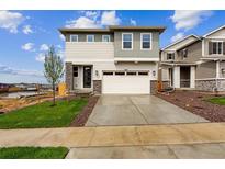 New construction two-story home with stone accents and a two-car garage at 9237 Truckee Ct, Commerce City, CO 80022