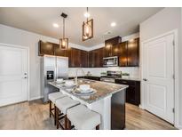 Modern kitchen features granite counters, stainless steel appliances, and seating at the kitchen island at 19714 W 93Rd Ln # C, Arvada, CO 80007