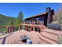 Expansive deck with cozy fire pit and views offers an inviting outdoor living space, perfect for relaxation and entertaining at 617 Hummingbird Trl, Idaho Springs, CO 80452