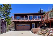 Charming two-story home features a spacious deck with mountain views and a convenient garage, nestled in a serene setting at 617 Hummingbird Trl, Idaho Springs, CO 80452