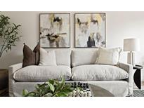 Comfortable living room showcasing a neutral sofa with decorative pillows and stylish abstract art at 9316 W Utah Ave, Lakewood, CO 80232