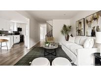 Bright living room featuring modern decor, wood floors, and an open layout into the kitchen at 9316 W Utah Ave, Lakewood, CO 80232