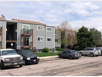 Exterior view of condo building with gray siding, brown trim, and private balcony at 16359 W 10Th Ave # 1, Golden, CO 80401