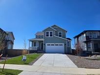 Charming two-story home with a wide driveway, manicured lawn, and a welcoming front porch at 6046 Keyser Pl, Brighton, CO 80601