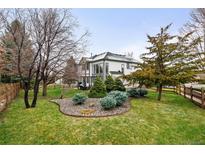 Landscaped backyard featuring a well-maintained lawn and patio area perfect for outdoor entertaining at 17705 W 63Rd Dr, Golden, CO 80403