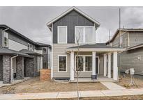 Charming two-story home boasts a welcoming front porch and modern gray and tan siding details at 710 Belay St, Erie, CO 80516