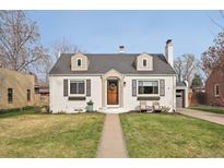 Charming home featuring a well-manicured lawn, a brick exterior, dormer windows, and an inviting front entrance at 2830 Forest St, Denver, CO 80207