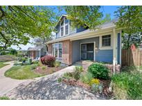 Inviting home with lush landscaping and a charming blue exterior provides great curb appeal at 7659 S Rosemary Cir, Englewood, CO 80112