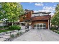 Stunning modern home with wood accents, a glass garage door, professional landscaping, and a spacious driveway at 445 Forest St, Denver, CO 80220