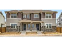 Charming two-story townhome with stone accents and covered front porch at 15228 Detroit St, Thornton, CO 80602