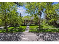 Charming brick home with lush lawn and mature trees; welcoming curb appeal at 2222 E 7Th Avenue Pkwy, Denver, CO 80206
