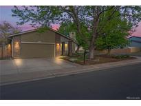 Charming home featuring a two-car garage, well-lit exterior, and a beautifully landscaped front yard at 2090 S Fairplay St, Aurora, CO 80014