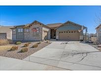 Charming single-Gathering home features stone accents, a well-manicured yard, and a wide driveway at 8016 Gore Creek Ln, Littleton, CO 80125