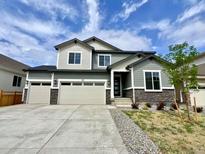 Charming two-story home featuring a three-car garage, stone accents, and a well-maintained front yard at 245 Wooten Ave, Brighton, CO 80601