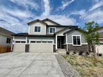 Charming two-story home featuring a three-car garage, stone accents, and well-manicured landscaping at 245 Wooten Ave, Brighton, CO 80601