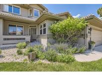 Beautiful front entrance with a well-manicured landscape, stone accents, and a charming walkway at 6435 Spotted Fawn Run, Littleton, CO 80125