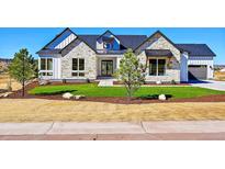Charming exterior elevation with stone accents, manicured lawn, and a welcoming entrance to this inviting home at 7572 Kelty Trl, Franktown, CO 80116