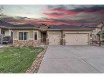 Charming stucco home with a two-car garage and stone accents against a dramatic sky at 9754 W Ontario Pl, Littleton, CO 80128