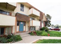 Charming apartment building with blue door, balconies, and landscaped front yard at 10211 Ura Ln # 9-308, Thornton, CO 80260