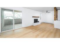 Bright living room featuring a cozy fireplace, hardwood floors, and access to an outdoor balcony at 3035 Oneal Pkwy # 20V, Boulder, CO 80301