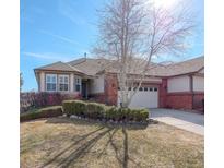 Charming single-story home featuring a brick facade, well-manicured landscaping, and an attached two-car garage at 8338 E 148Th Way, Thornton, CO 80602